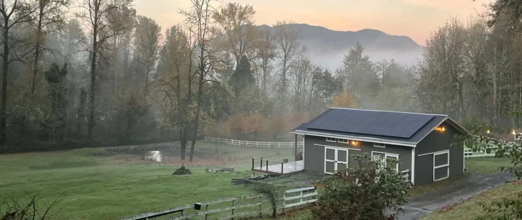 building with solar on roof and mountains in background