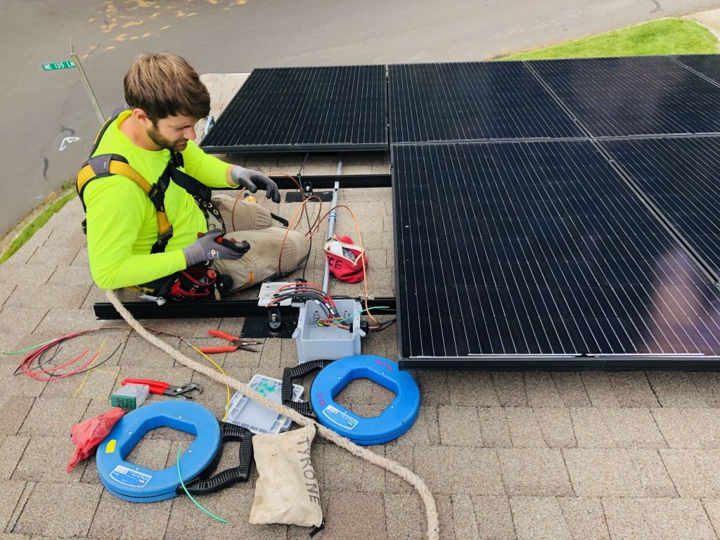 solar installer on roof wiring junction box
