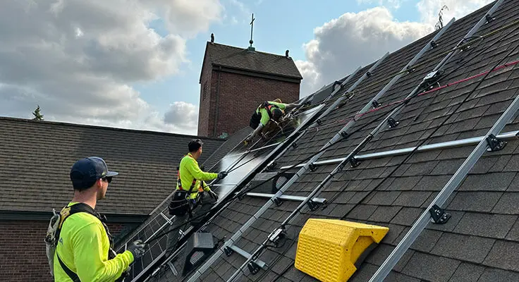 Solar installers installing panels on a Pacific Northwest roof