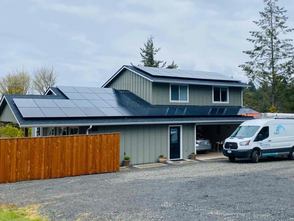 House with panels on roof and A&R van in front